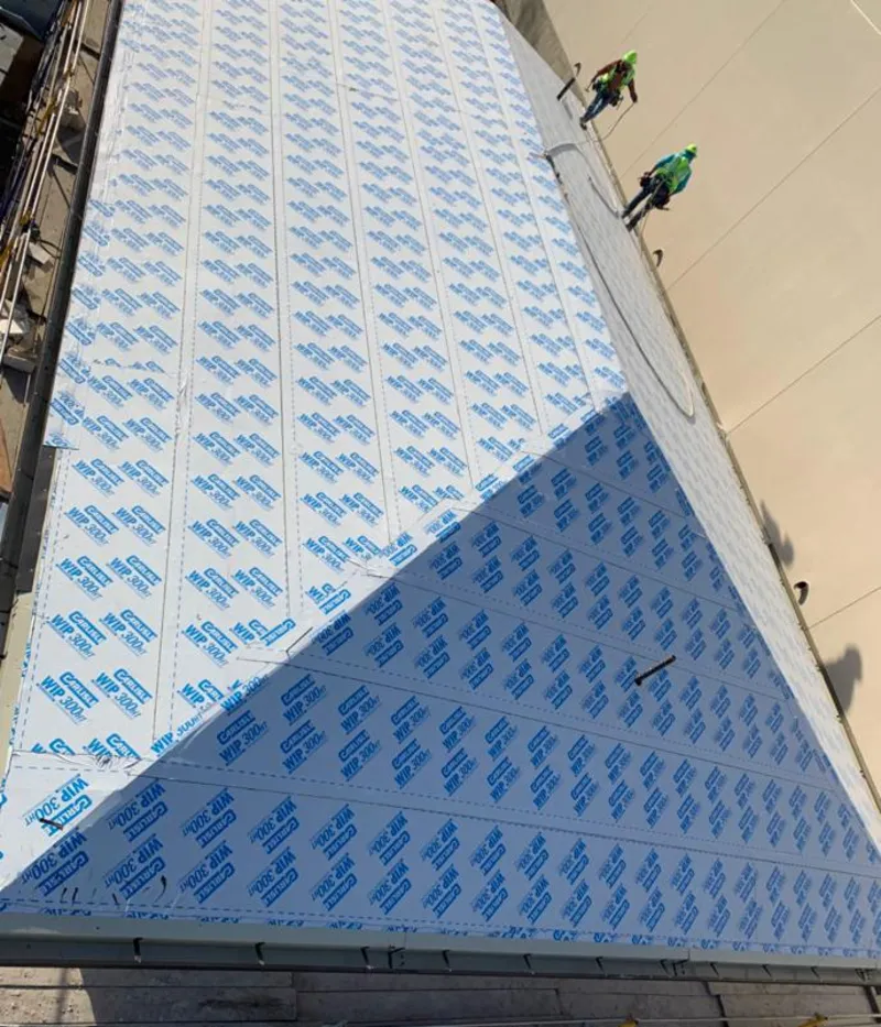 Professional roofers installing underlayment on a metal roof in Carlinville